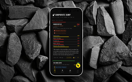 The Corporate Dump™ app on a phone against dark stone — a field report for Dunder Mifflin scored 2.4, with rated categories for cleanliness, stall privacy, and supply quality above a written review